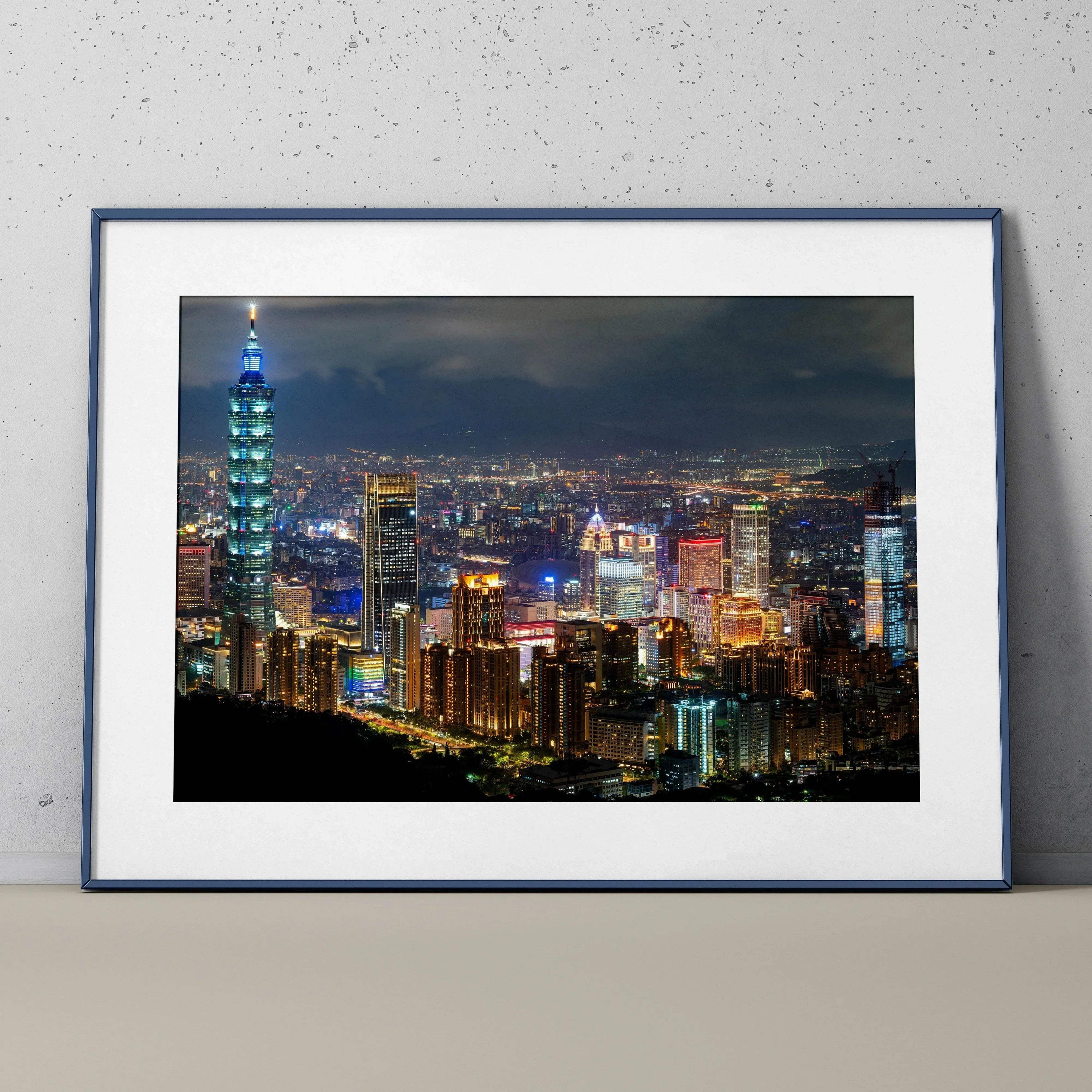 City night skyline wall art poster featuring illuminated skyscrapers and city lights in a black frame.