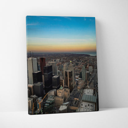 Vertical canvas wall art featuring a high-resolution city skyline at sunset with vibrant blue and orange sky colors.