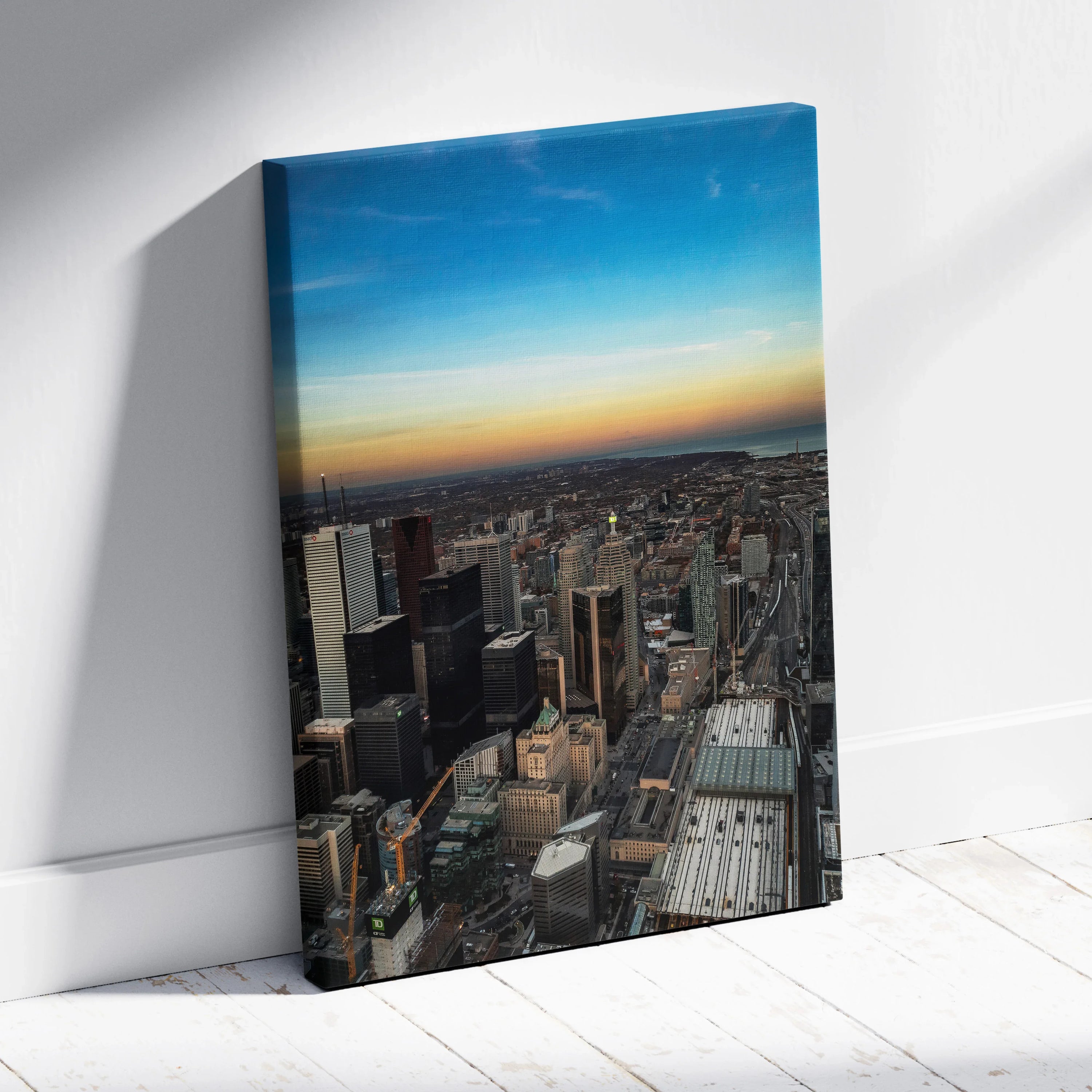 Vertical canvas wall art featuring a stunning city skyline at sunset with vibrant sky hues.