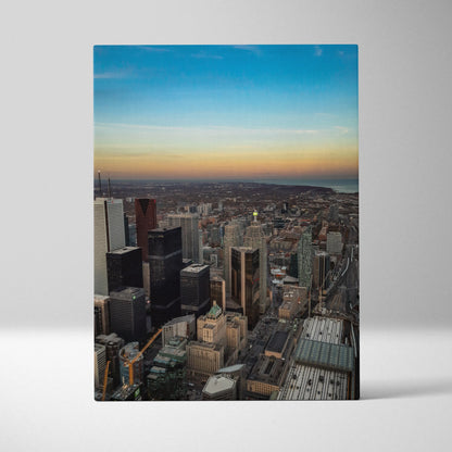 Vertical canvas wall art featuring a stunning city skyline at sunset with detailed buildings and vibrant sky colors.
