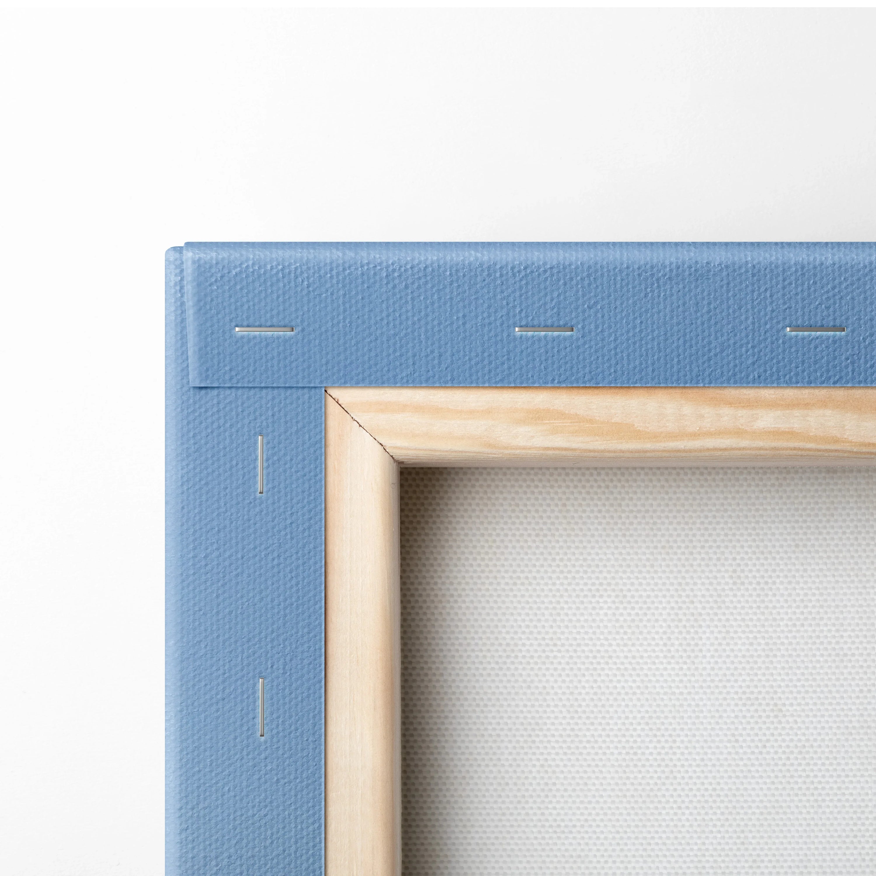Close-up of wooden frame and blue canvas backing on canvas wall art print.