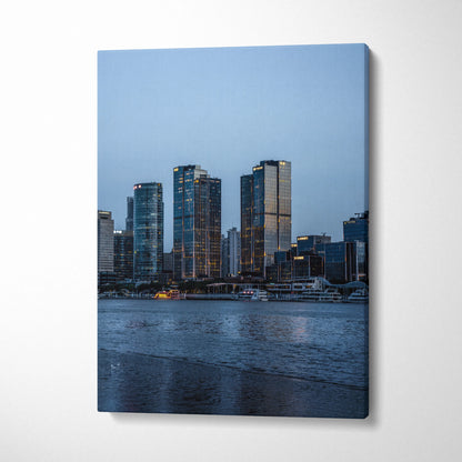 Canvas wall art featuring a serene urban cityscape with illuminated skyscrapers at dusk.