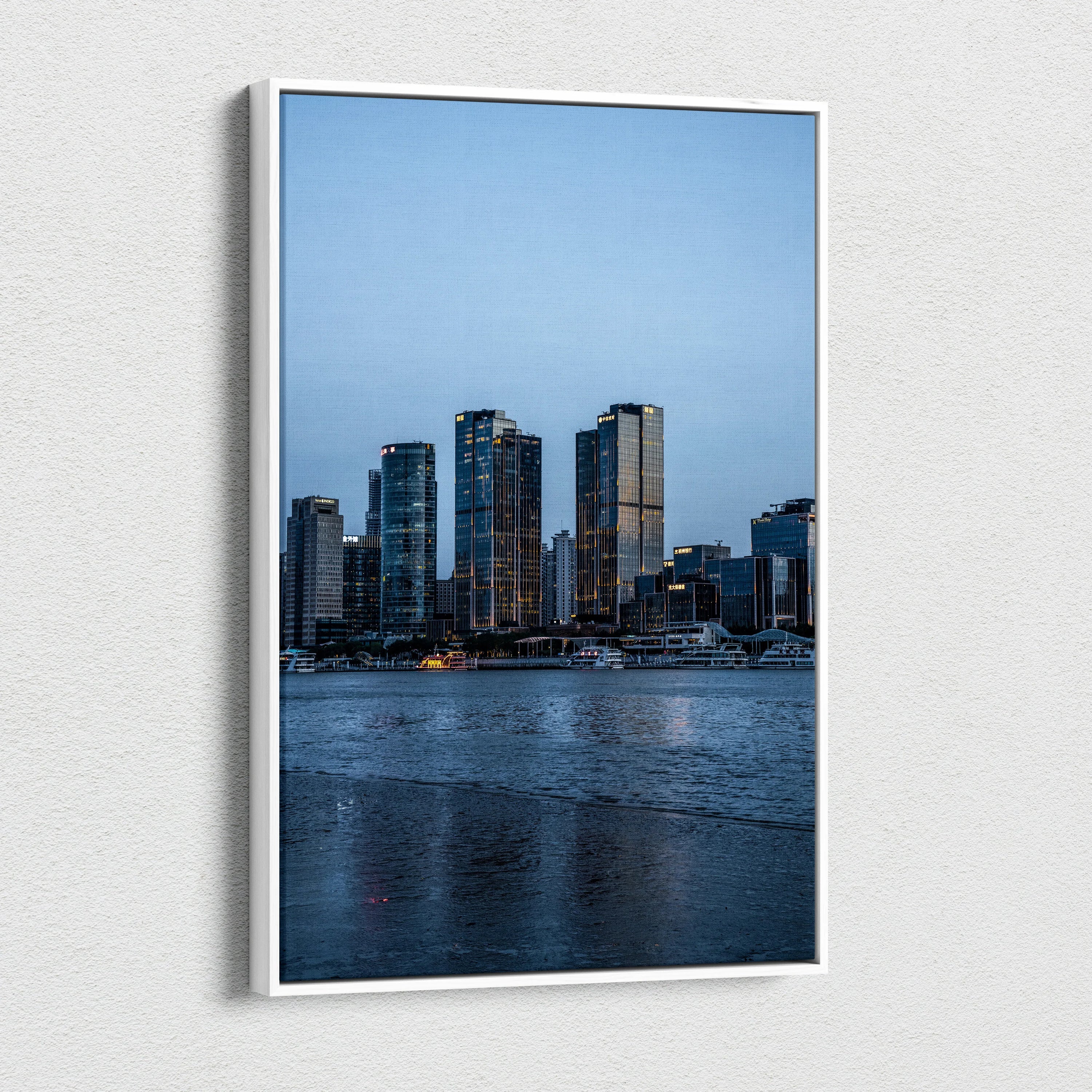 Vertical canvas wall art featuring a vibrant cityscape with tall buildings at dusk.