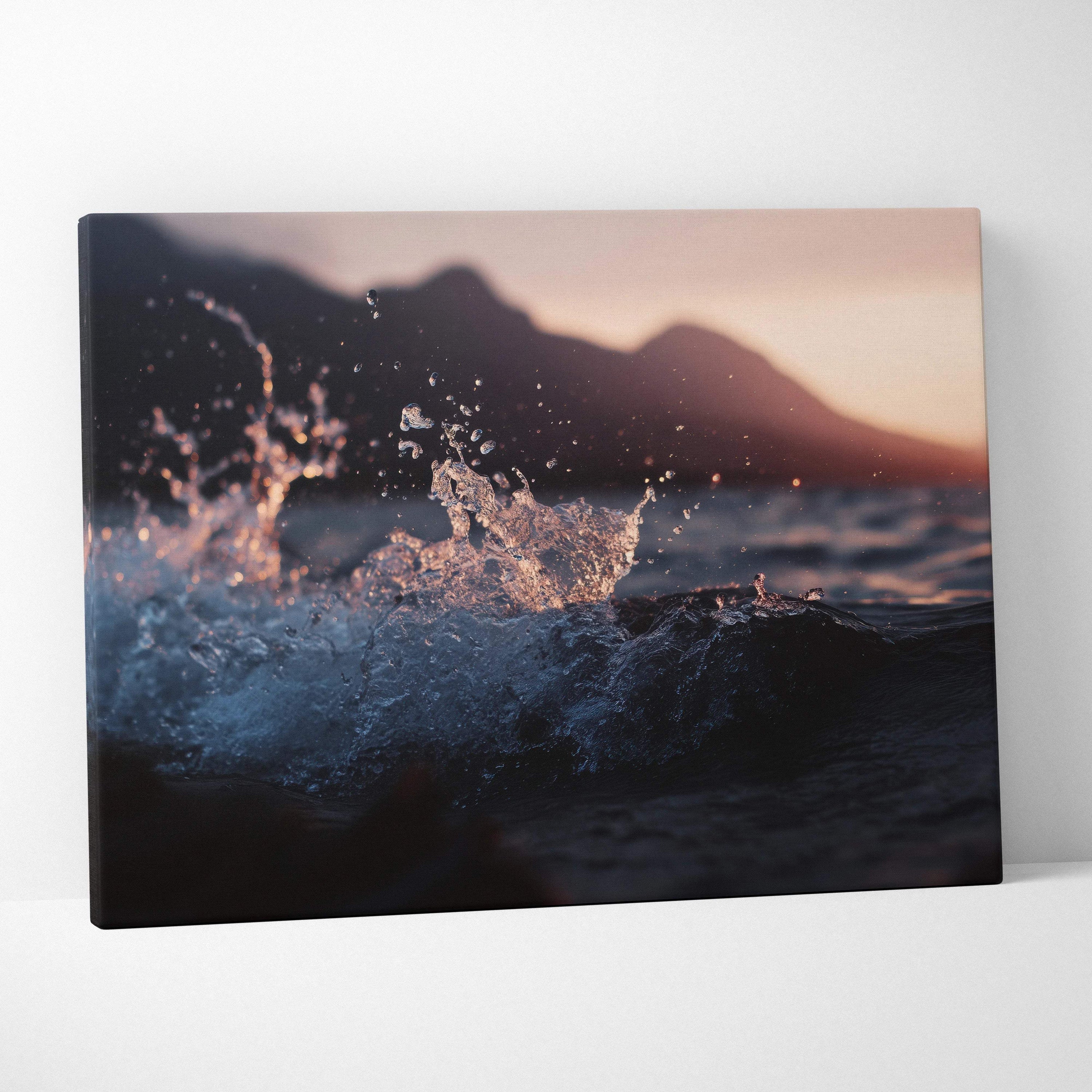 Moody cinematic ocean wave at sunset with distant mountains canvas art
