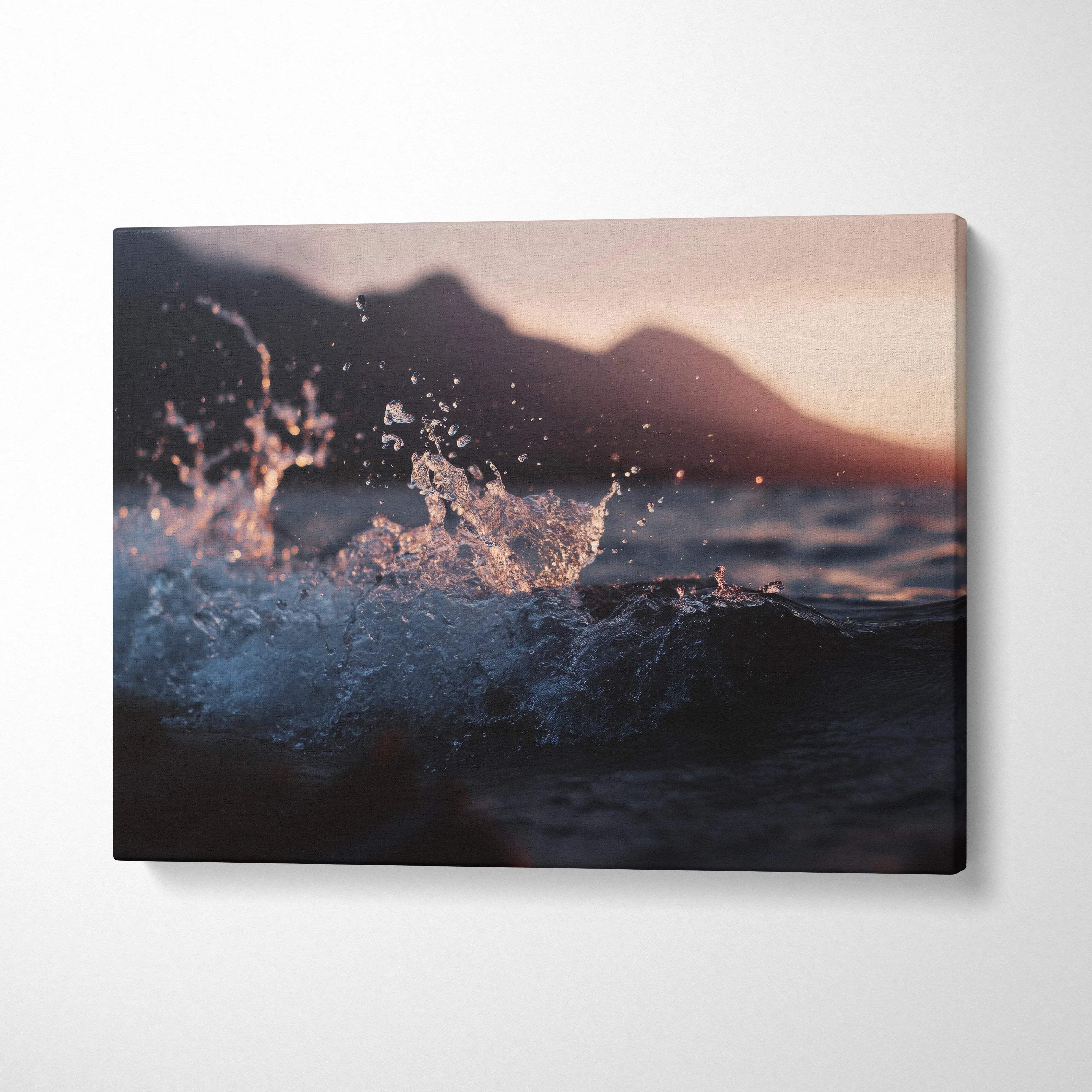 Moody cinematic ocean wave at sunset with distant mountains canvas art