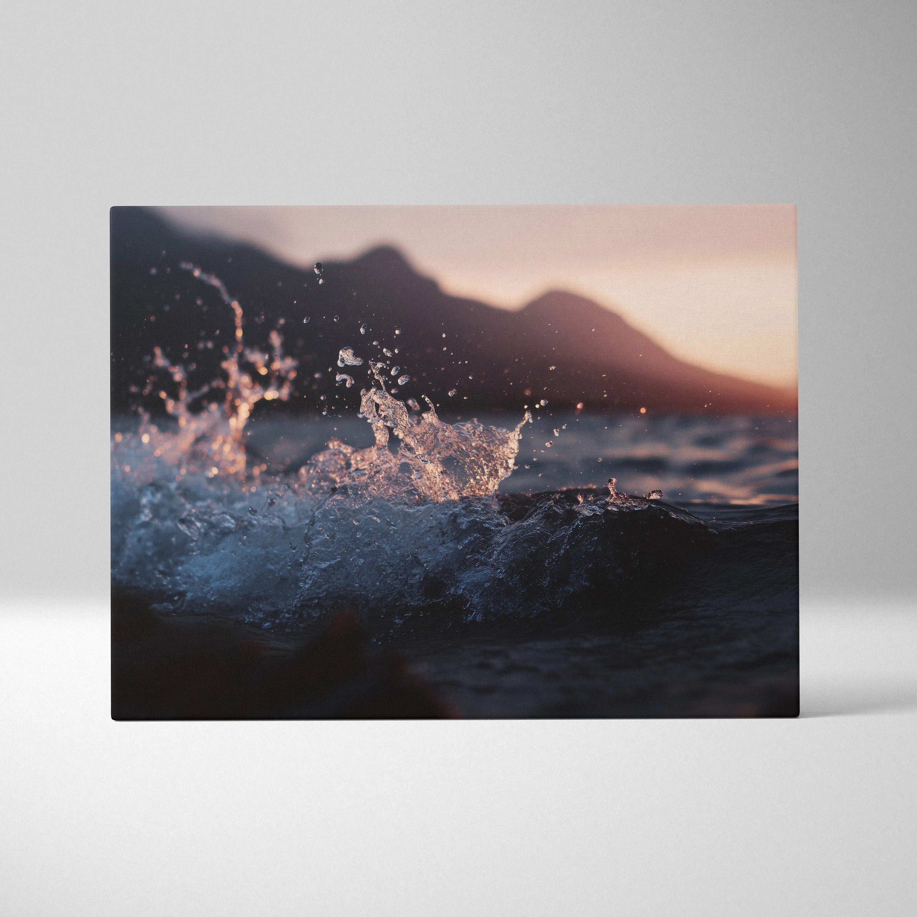 Moody cinematic ocean wave at sunset with mountains canvas wall art