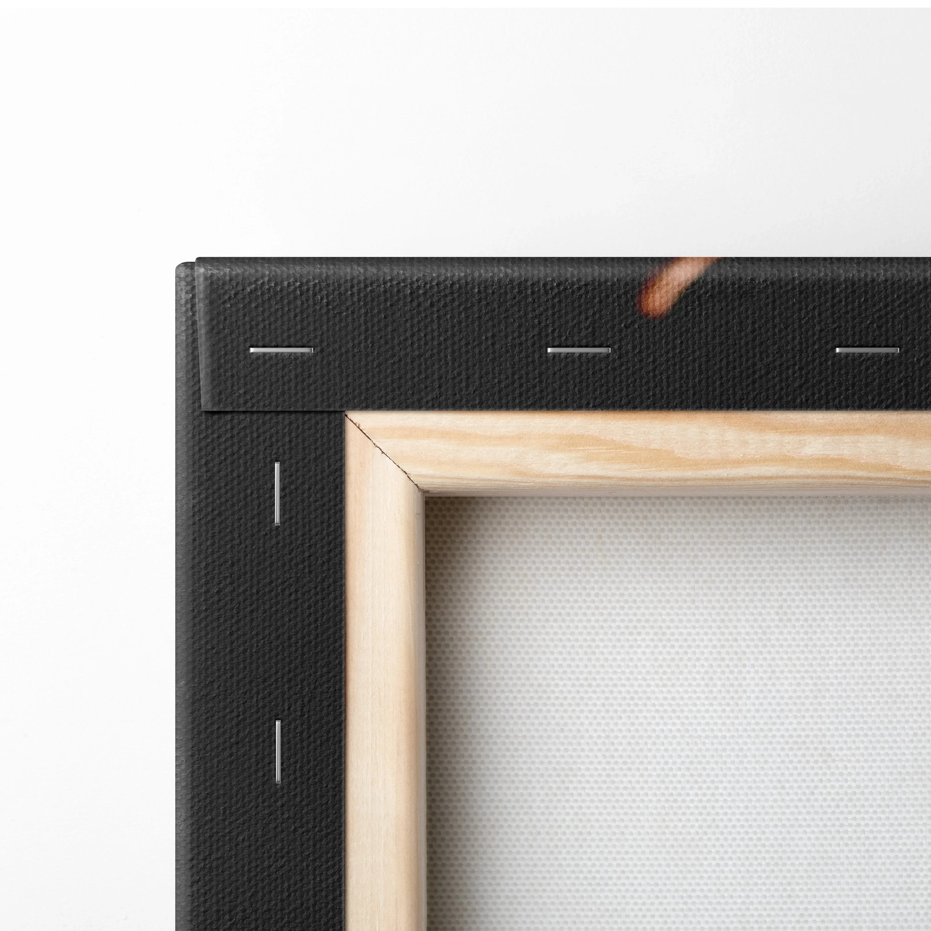 Corner detail of stretched canvas wall art with black edge and natural wood frame.