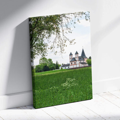 Canvas wall art featuring a historic castle building surrounded by green grass and trees under a clear sky.