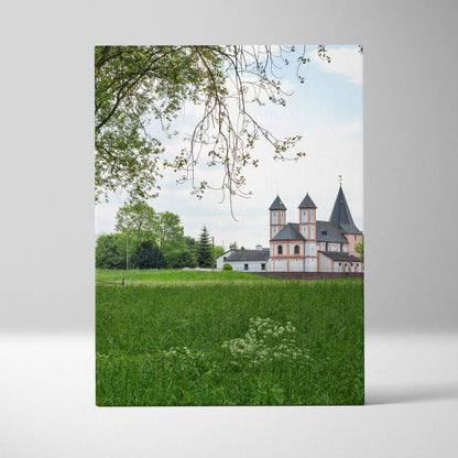 Canvas wall art featuring urban buildings with green field and tree branches in foreground.