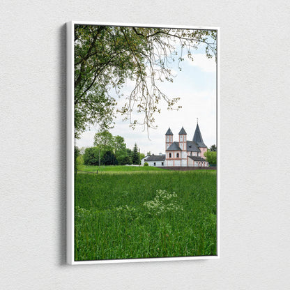 Vertical canvas wall art featuring a historic building with twin towers surrounded by green field and trees.