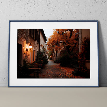 Autumn nature digital art poster with orange-leafed tree lining a cozy cobblestone street, wall art in dark frame.