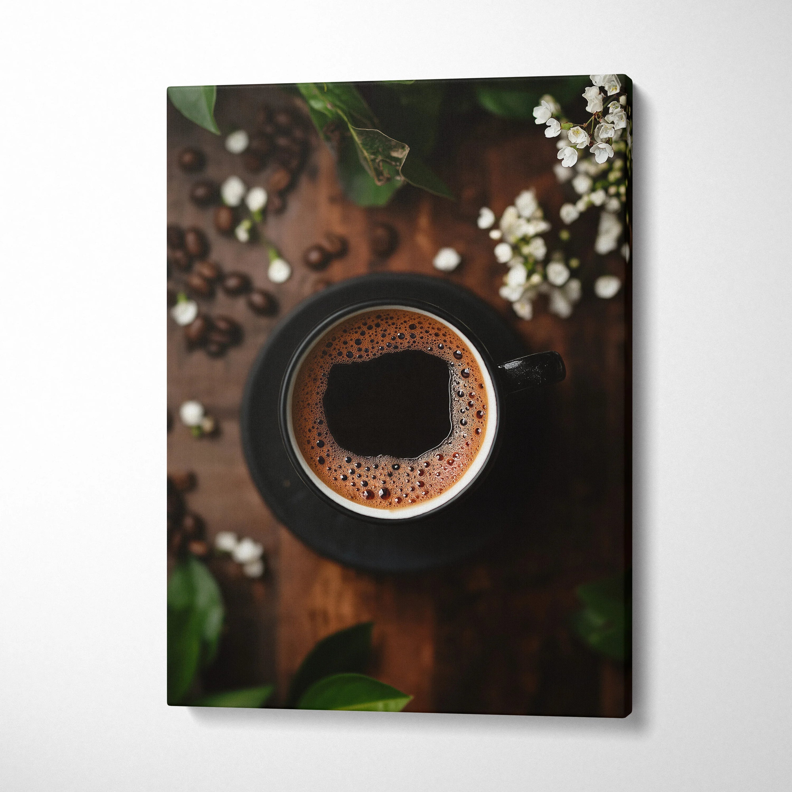 Vertical canvas wall art featuring a top-down view of a black coffee cup with frothy coffee on wooden table with coffee.