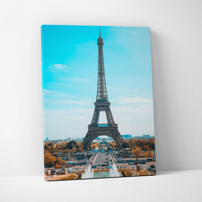 Eiffel Tower canvas wall art print with bright blue sky and Paris cityscape background.