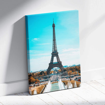 Vertical canvas wall art featuring the Eiffel Tower against a bright blue sky.