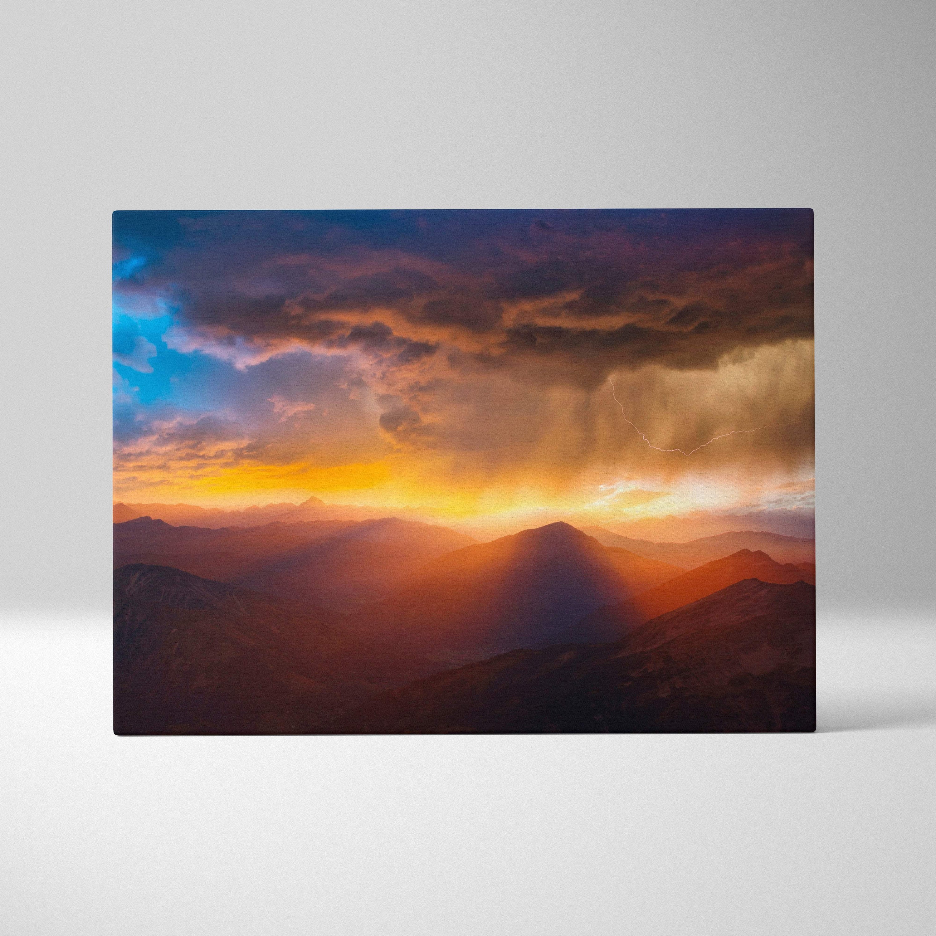 Rectangular canvas print of mountain storm sunset featuring golden light, deep blue sky, and dramatic lightning over peaks