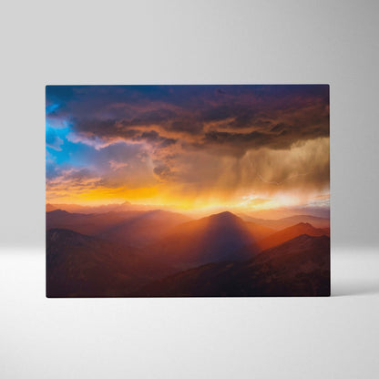 Rectangular canvas print of mountain storm sunset featuring golden light, deep blue sky, and dramatic lightning over peaks