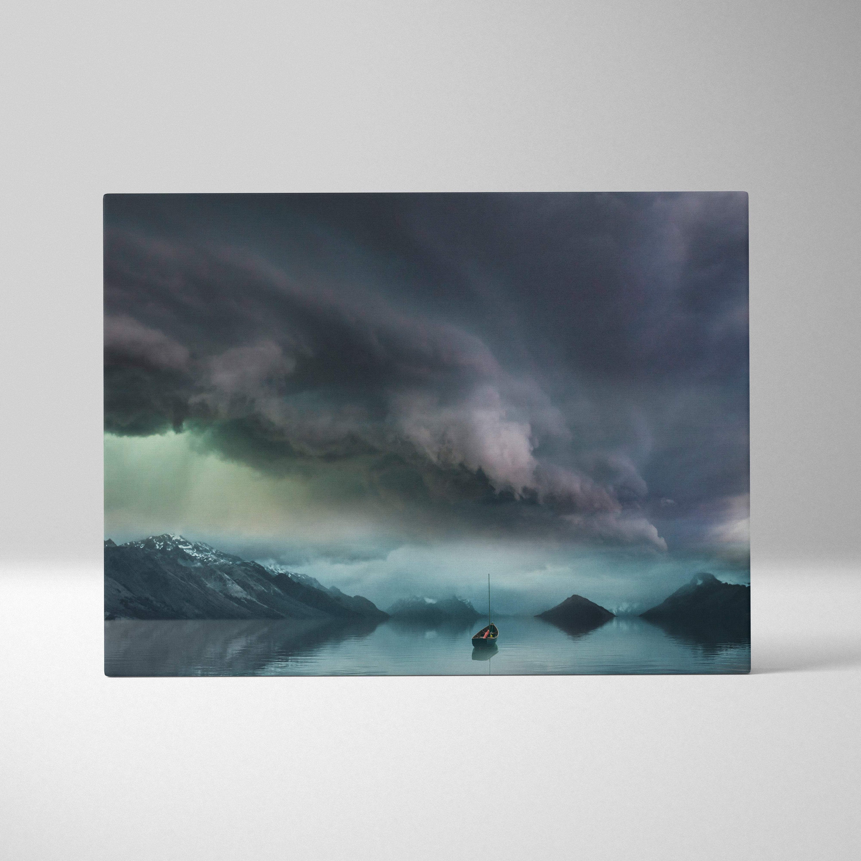 Rectangular canvas print of moody stormy sky with dark clouds over misty mountains and a lone sailboat on calm water
