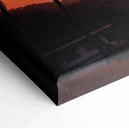 Corner view of vibrant sunset landscape canvas wall art with rich orange and dark tones.