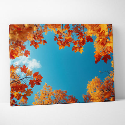 Canvas wall art of vivid orange and yellow autumn leaves framing a clear blue sky.