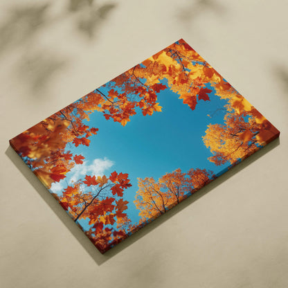 Canvas wall art featuring vivid autumn leaves in orange and red framing a bright blue sky.