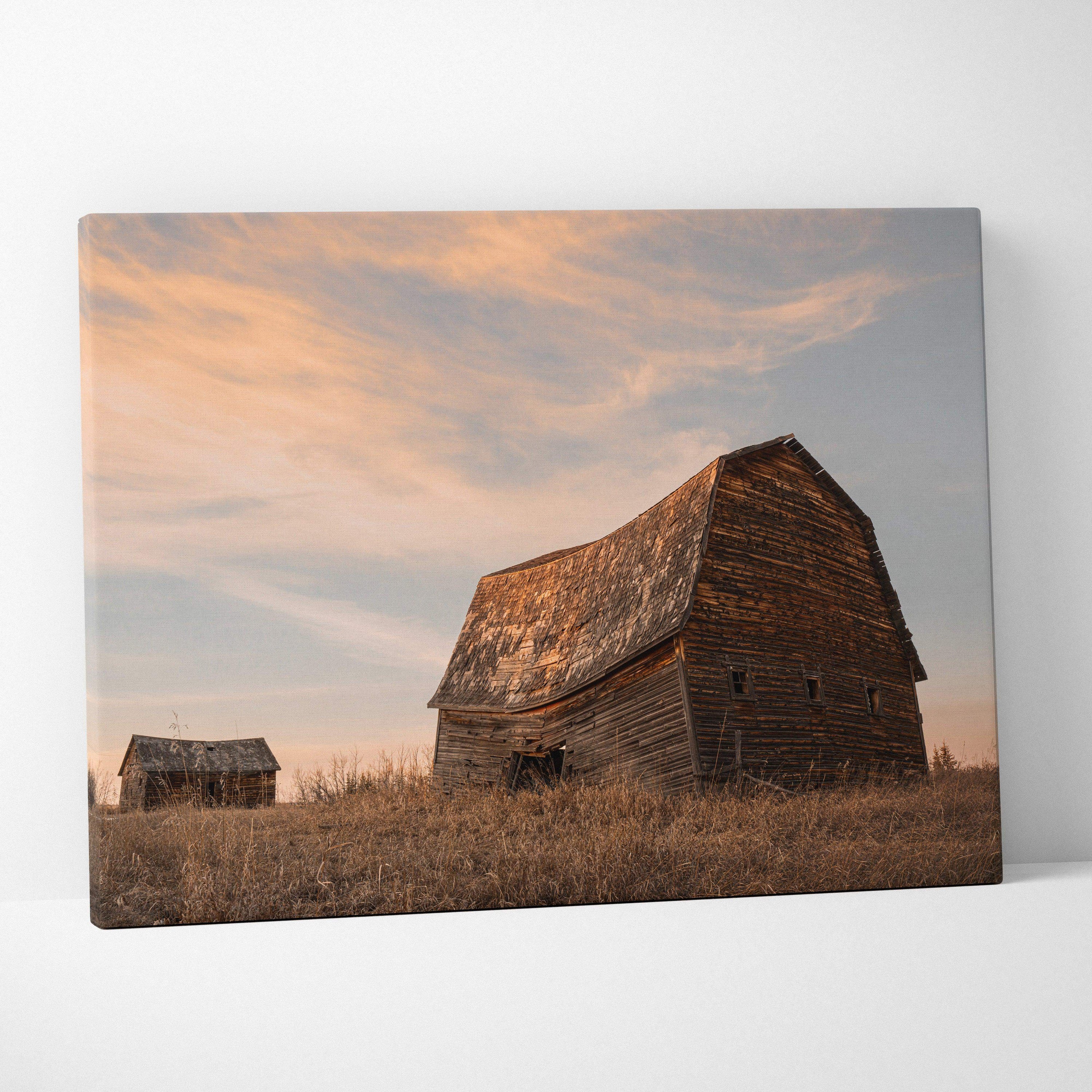 Canvas wall art featuring rustic wooden barns under a soft sunset sky in a rural setting.