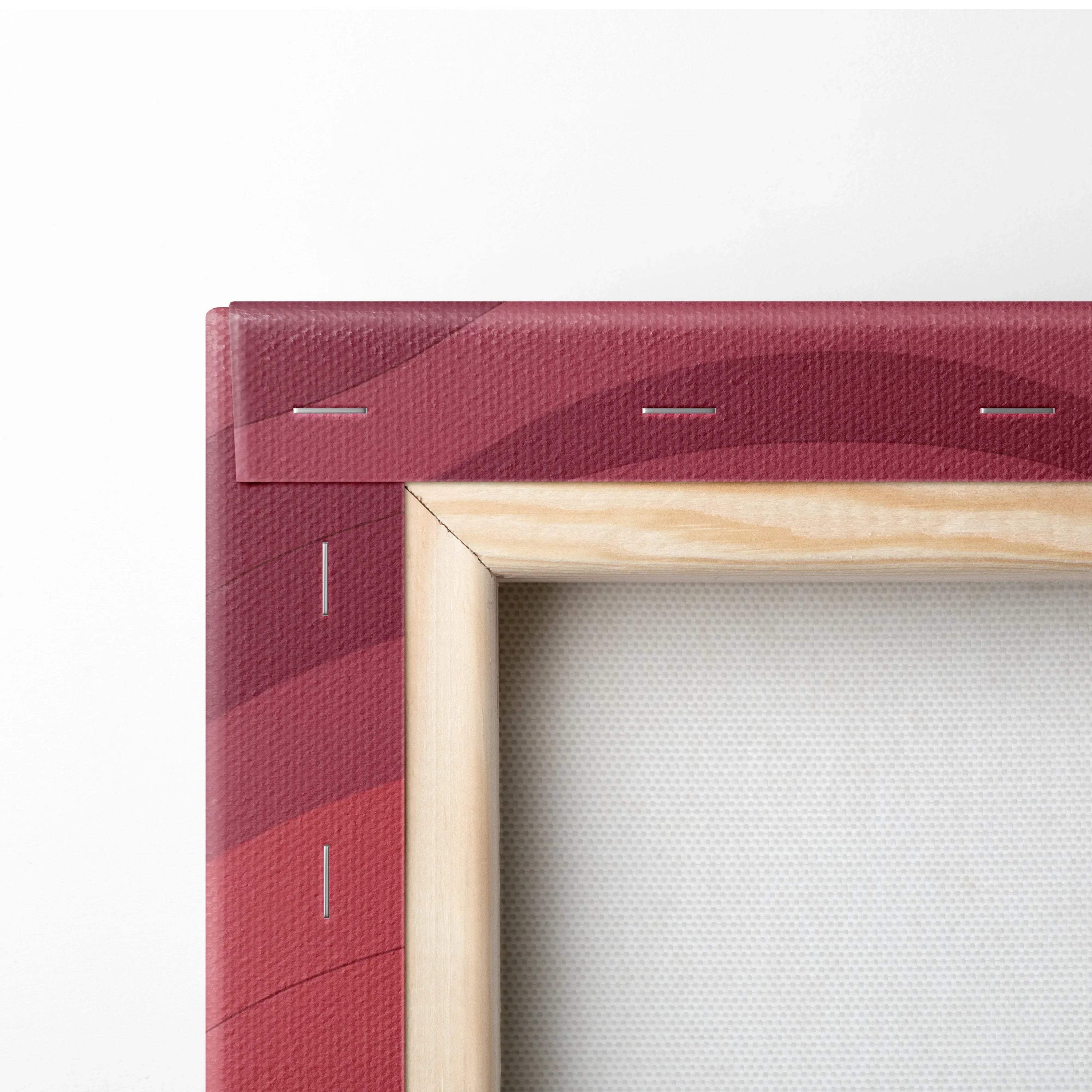 Close-up of a stretched canvas wall art corner with layered red and maroon abstract design on wood frame.