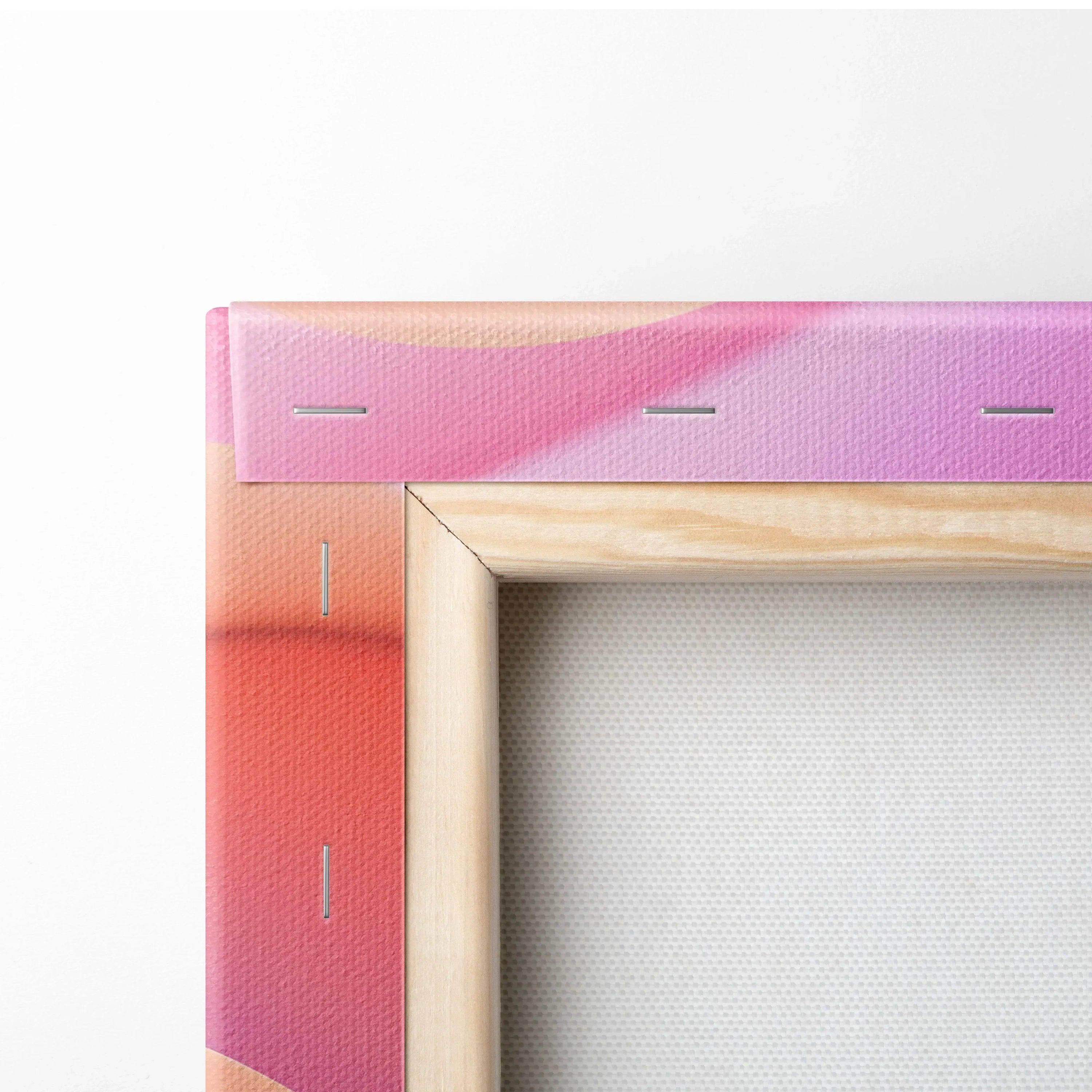 Close-up of stretched canvas corner with vibrant pink and orange abstract print and natural wood frame.