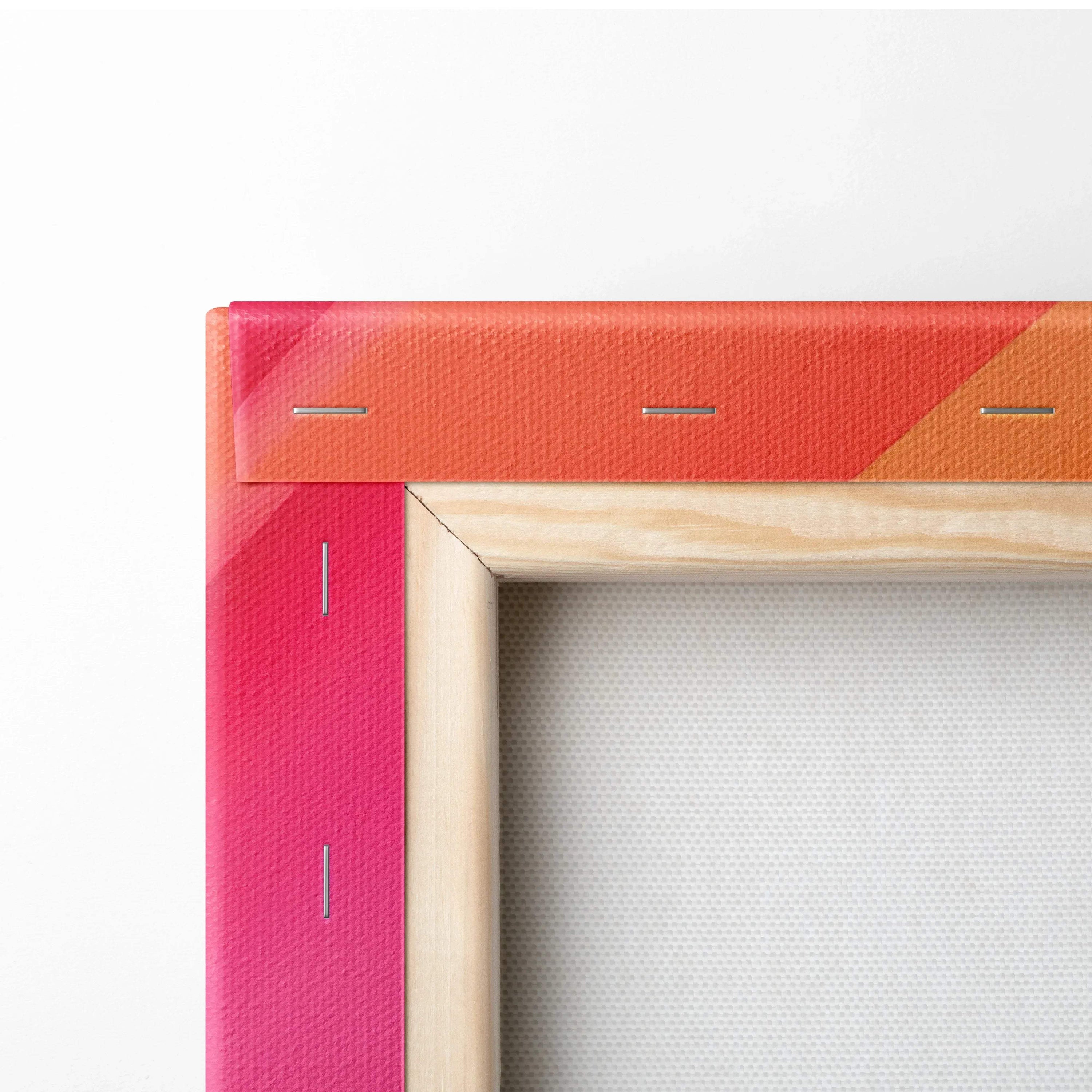 Close-up of corner on stretched canvas wall art with vibrant red, pink, and orange abstract design and wooden frame.