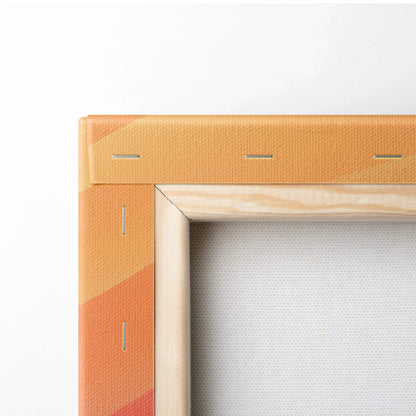 Corner of stretched canvas wall art with orange and peach abstract design and natural wood frame edges.