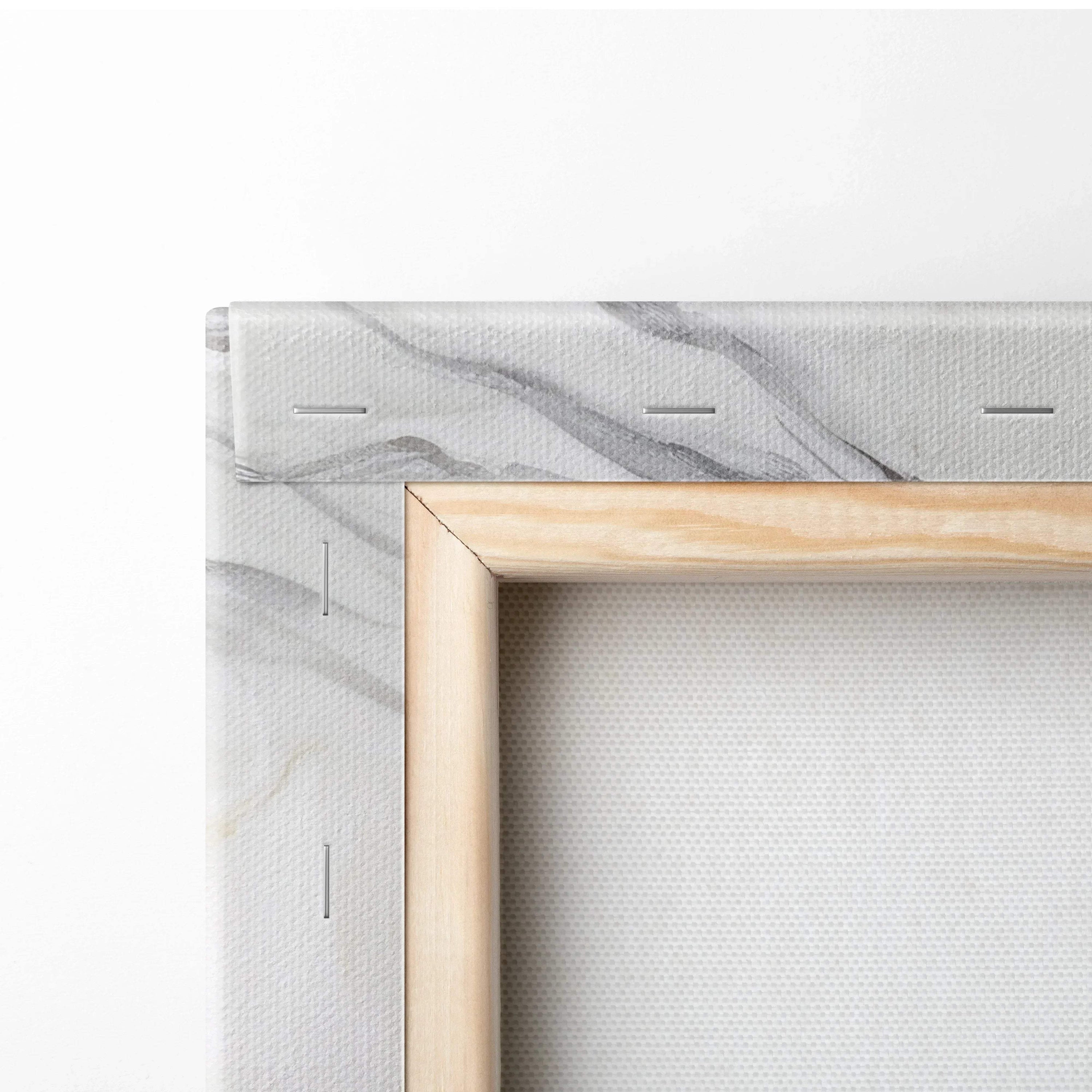 Close-up of wooden stretcher frame with white canvas stretched and stapled, showing subtle gray abstract patterns on canvas.