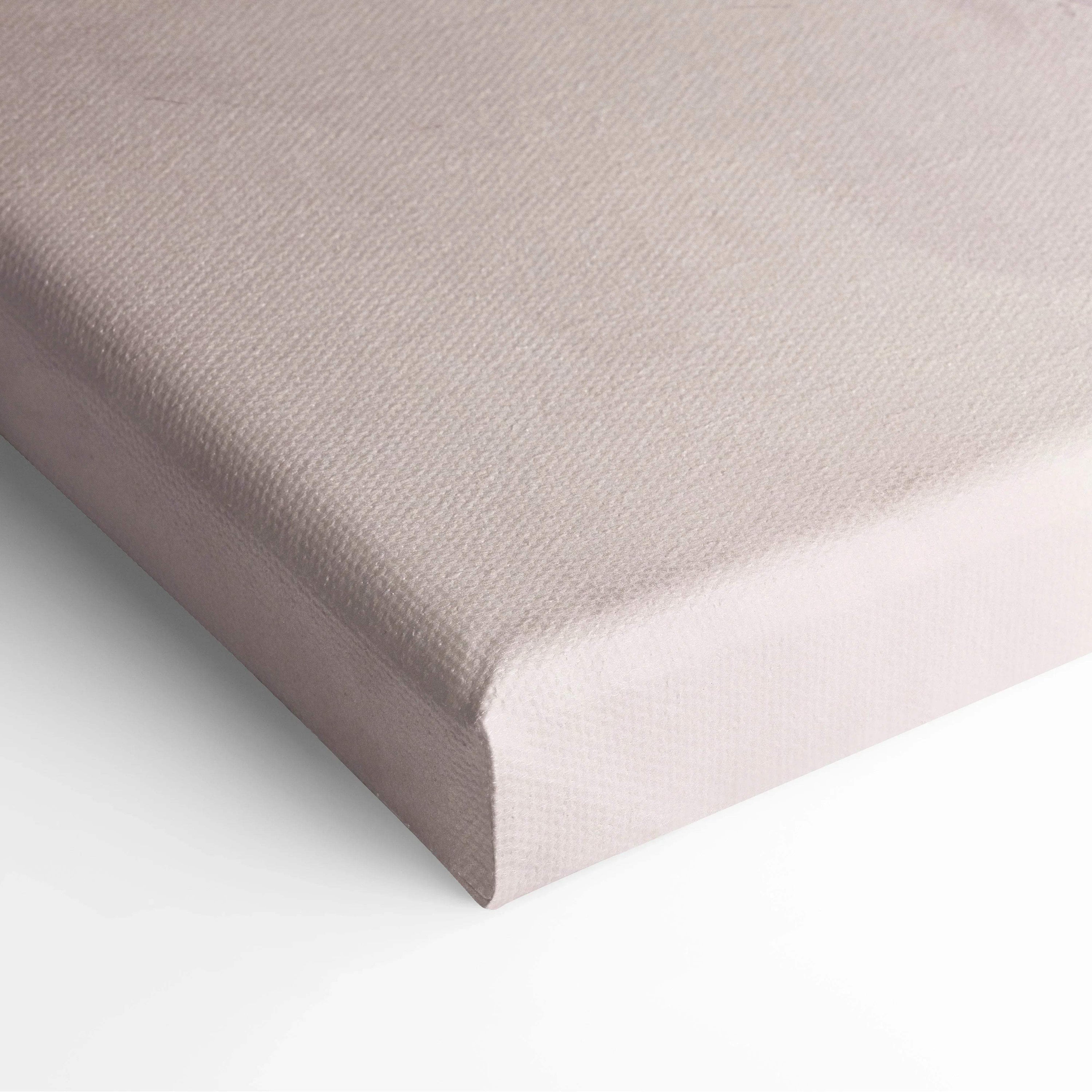 Close-up of a stretched canvas with a smooth beige fabric surface and neatly wrapped edges for wall art display.