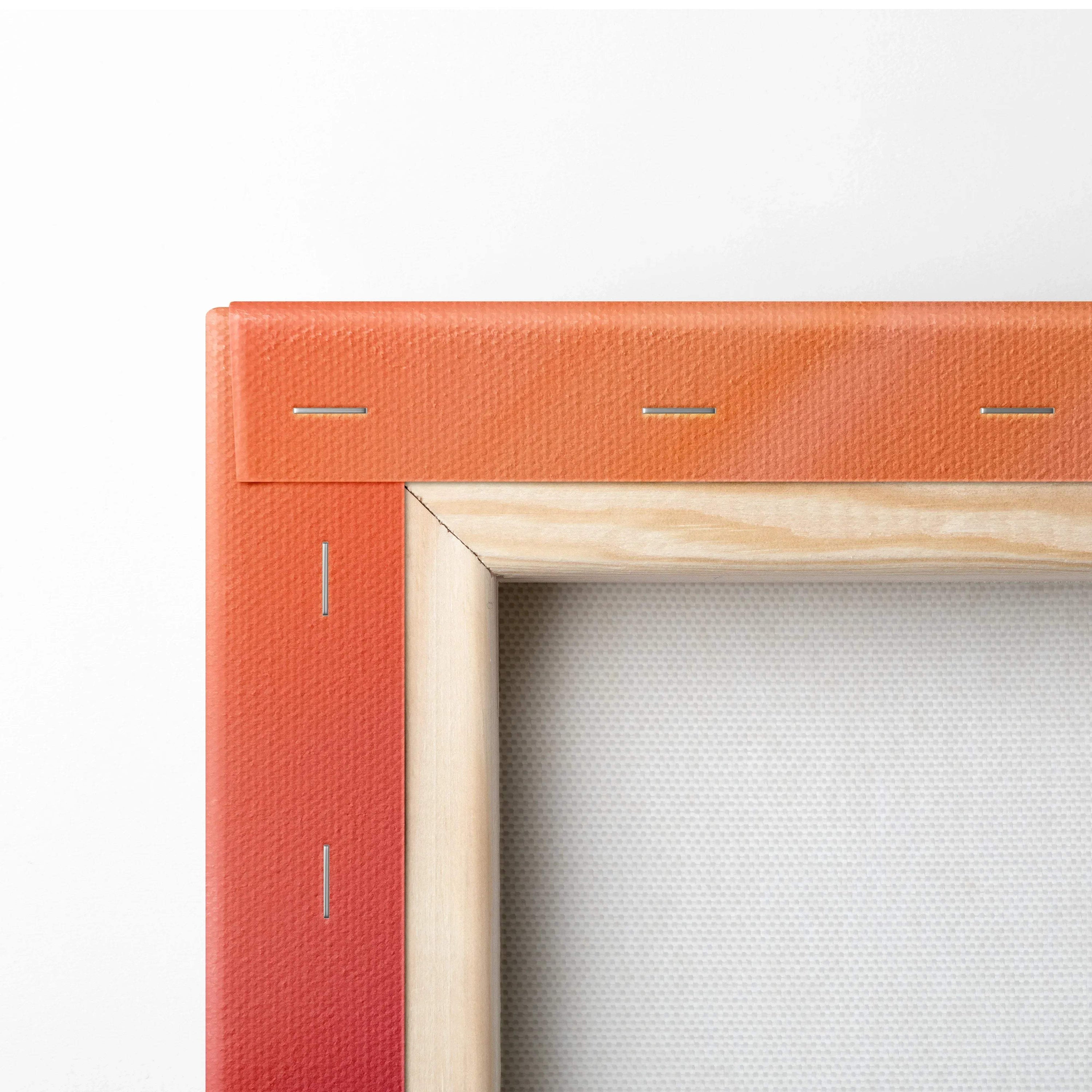 Close-up of a stretched canvas corner with vibrant orange gradient and natural wood frame edges.