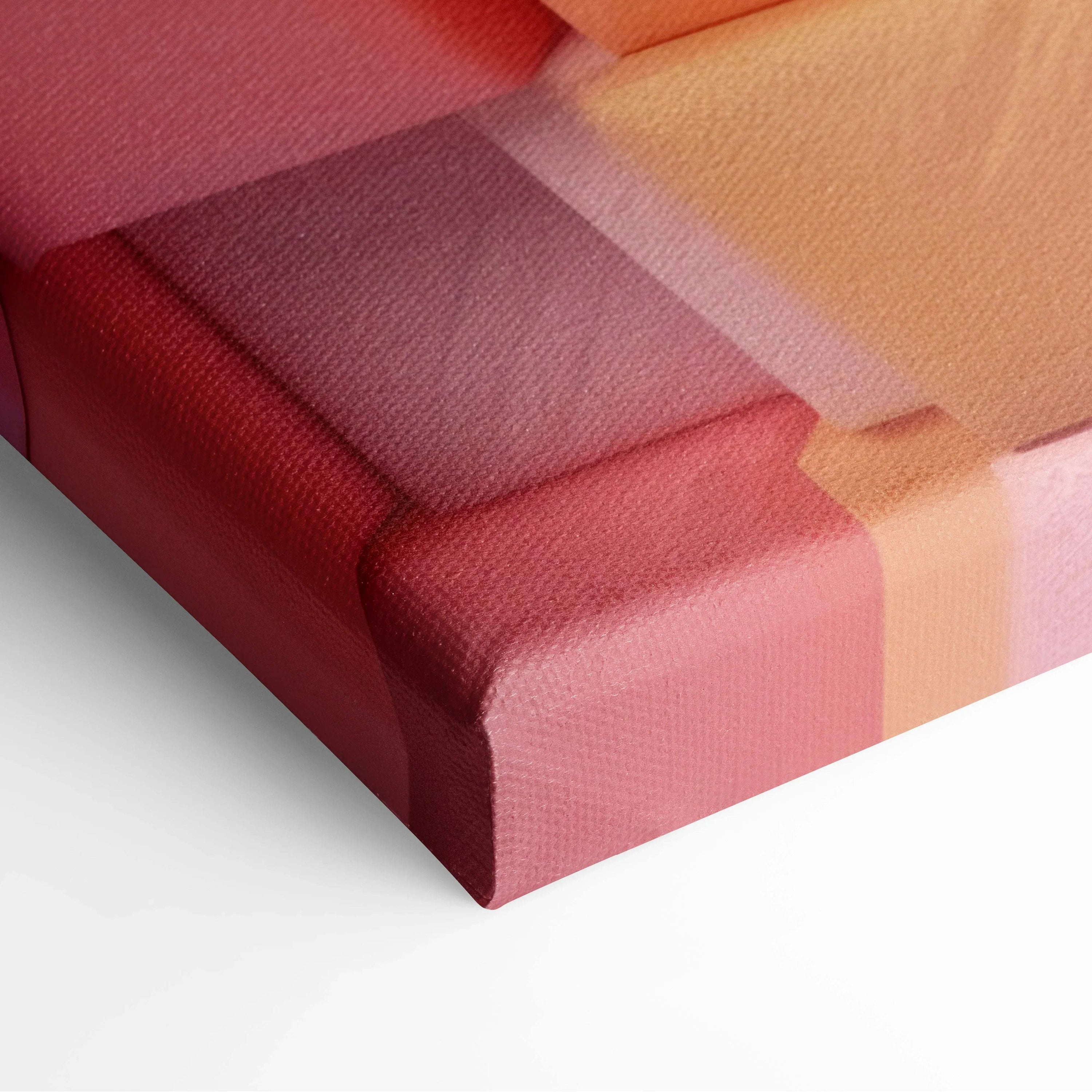 Close-up of canvas art with overlapping translucent shapes in red, pink, and peach tones, highlighting texture and vivid.