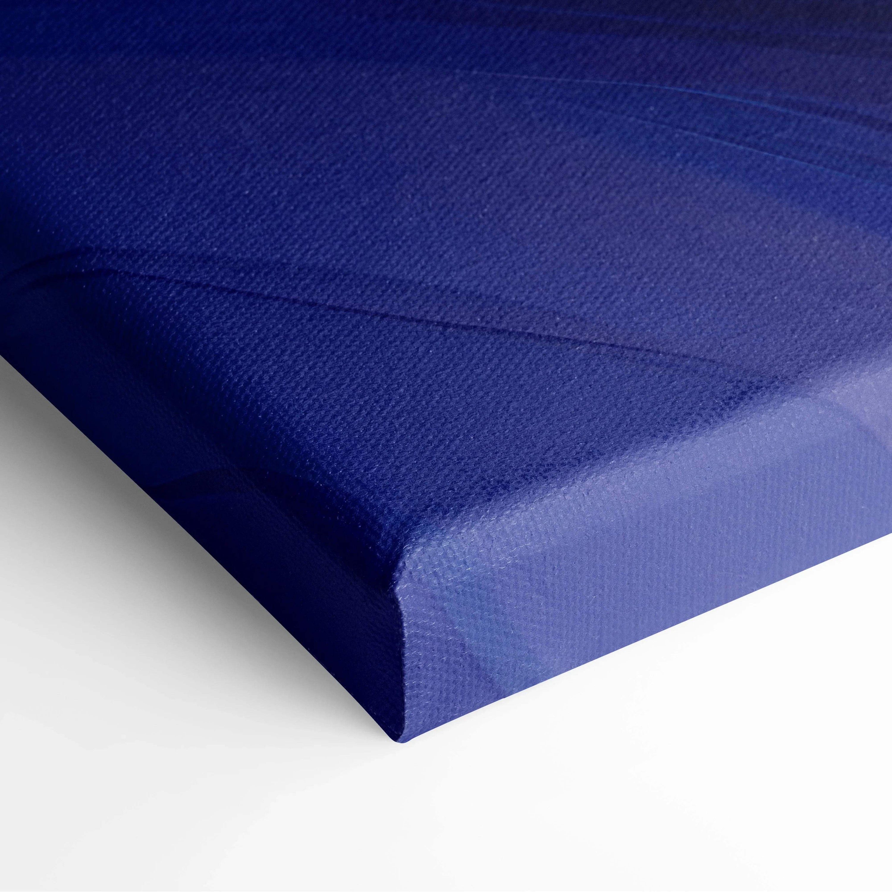 Close-up of deep blue textured canvas art print with subtle abstract design and wrapped edges.