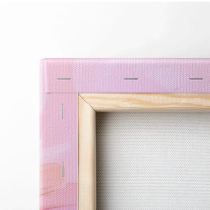 Close-up of pink abstract digital art on stretched canvas with wooden frame and visible staples.