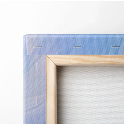 Close-up of wooden stretcher frame with blue-purple abstract print canvas tautly wrapped and stapled on the back.