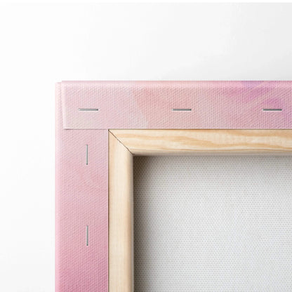 Close-up of canvas art corner with pink gradient fabric stretched over wooden frame with visible staples.