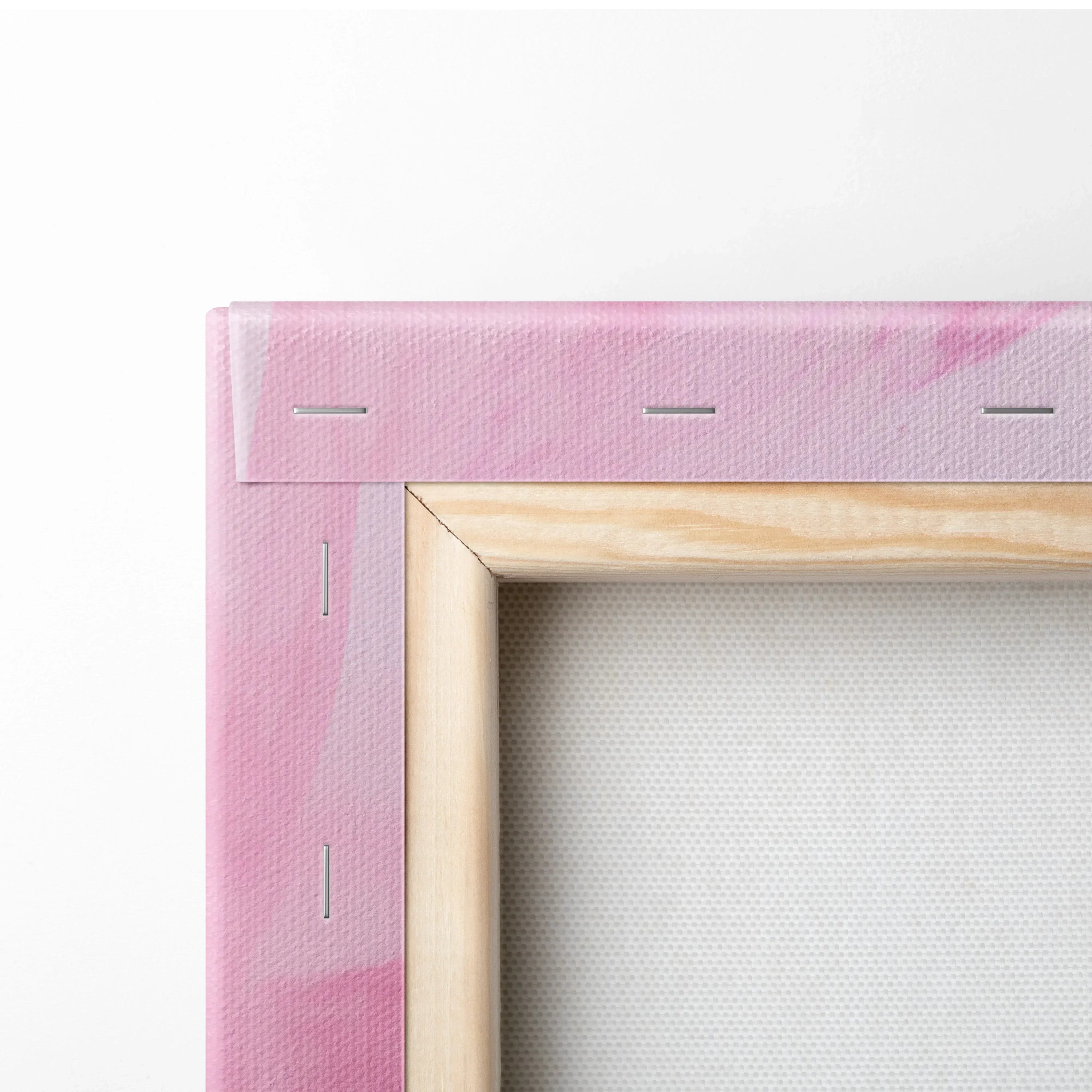 Corner view of pink abstract digital art canvas with wooden frame and stapled edges.