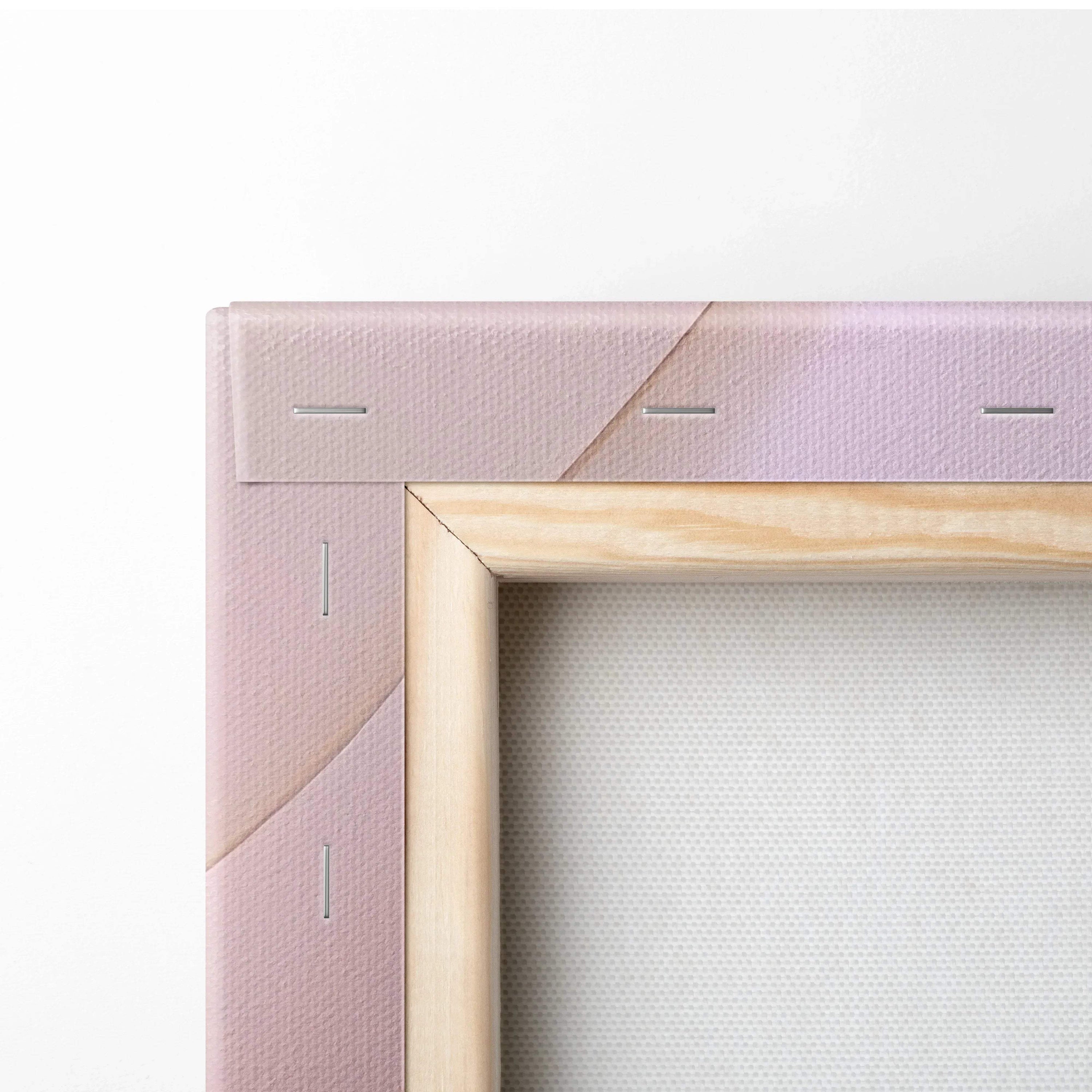 Close-up of canvas edges stretched on a wooden frame with soft pink and lavender tones.