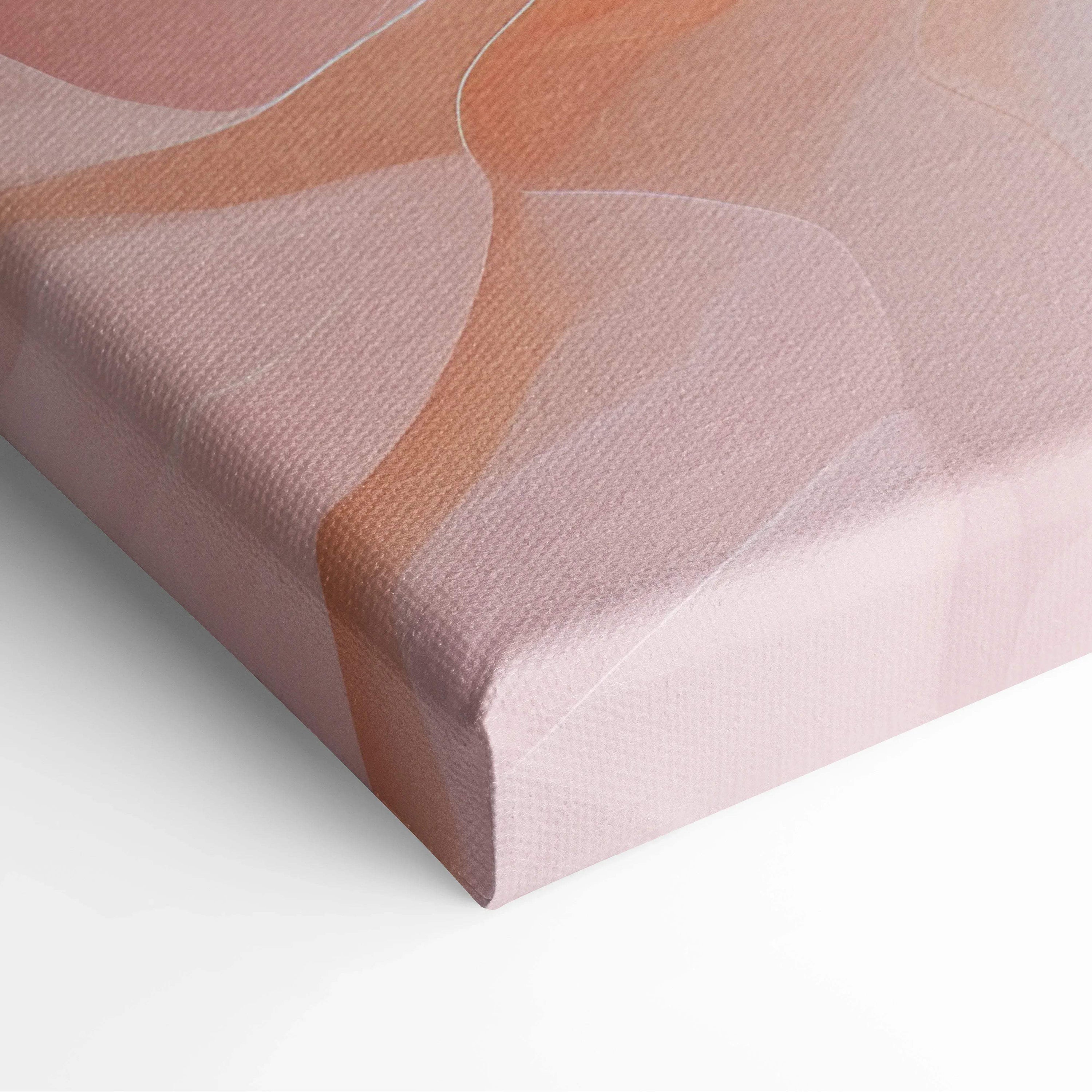 Close-up of canvas wall art with flowing abstract shapes in soft peach, pink, and beige tones on textured fabric.