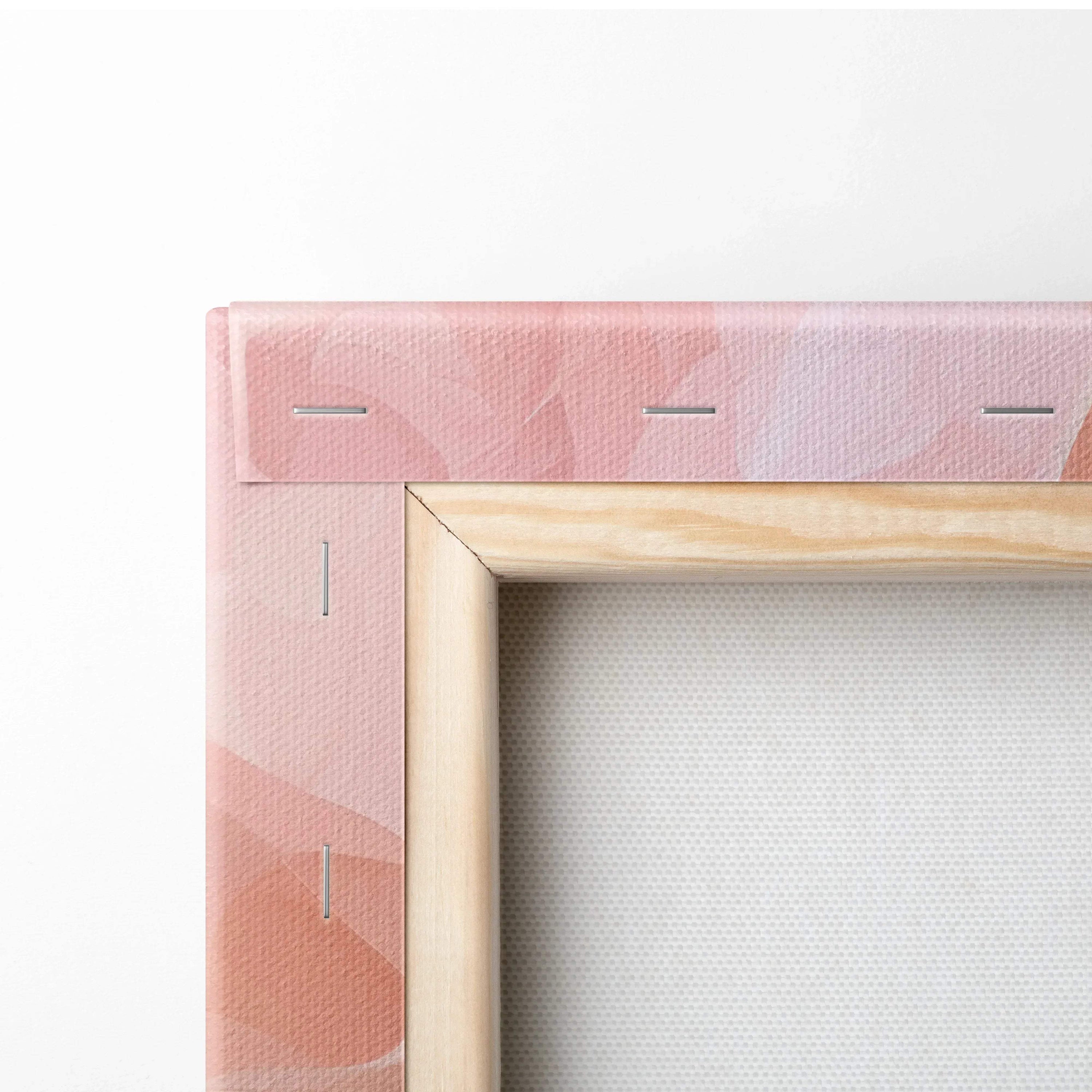 Corner detail of a stretched canvas with soft pink abstract digital art and wooden frame edges.
