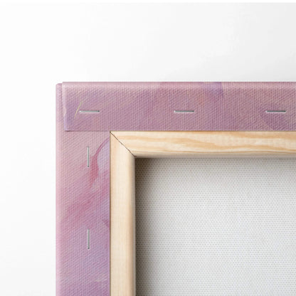Close-up of stretched digital canvas wall art with wooden frame and abstract pink-purple hues.