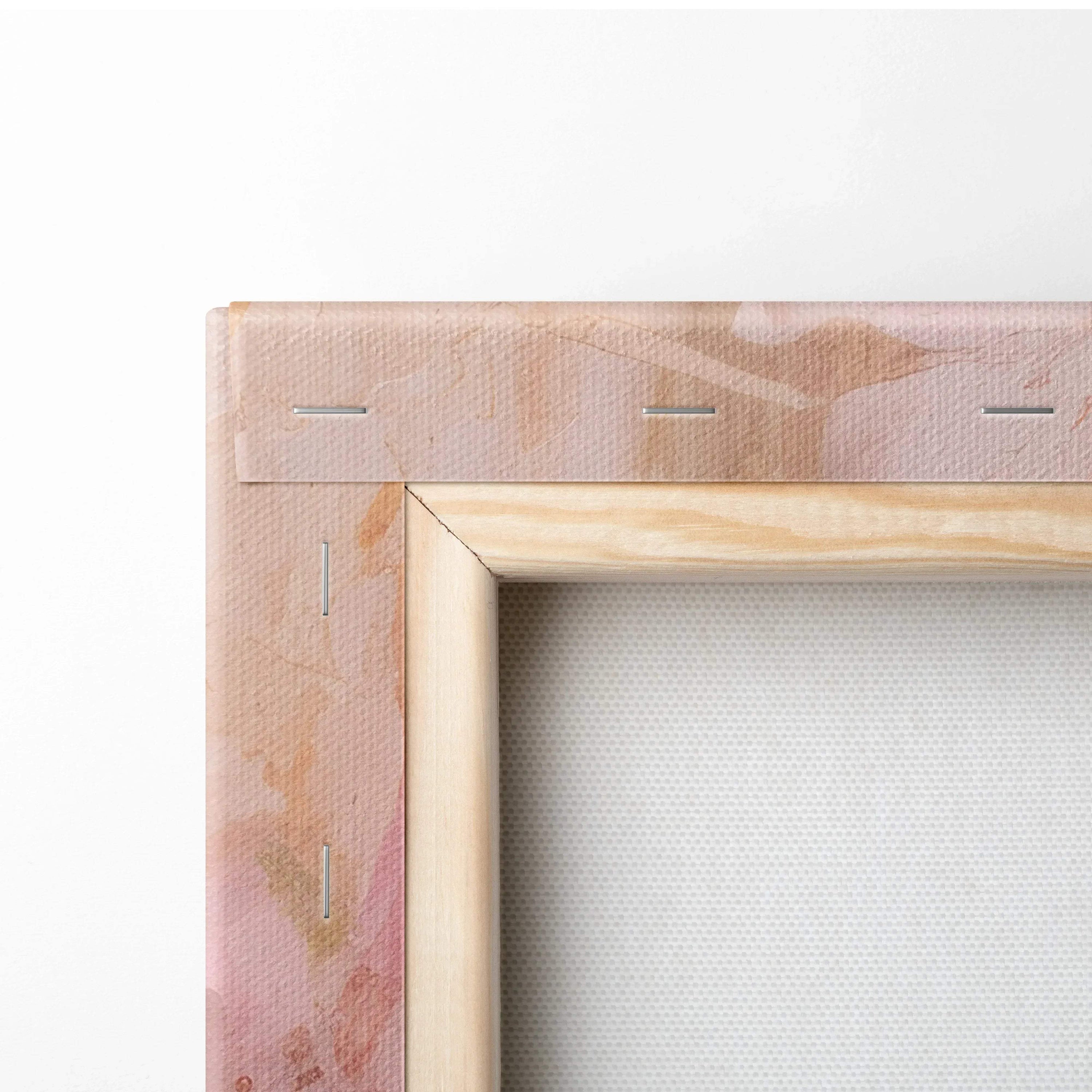 Close-up of stretched canvas on wooden frame with soft pink and beige abstract design on back.