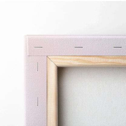 Close-up of wooden-framed canvas edge with light pink fabric stretched and stapled for wall art decor.