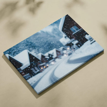 Canvas wall art featuring a snowy winter village scene with snow-covered rooftops and falling snowflakes.
