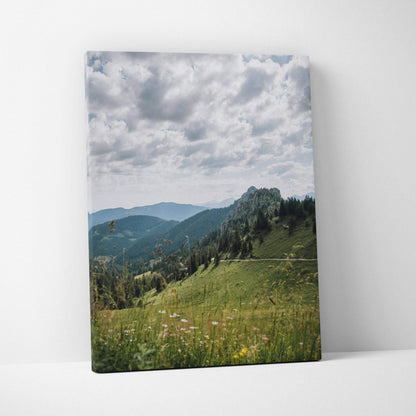 Canvas wall art featuring serene green mountains under a cloudy sky with wildflowers in foreground.