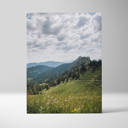 Canvas wall art featuring serene green mountains under a cloudy sky with wildflowers in foreground.