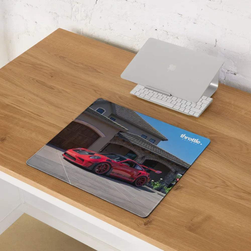 Rectangular throttle gaming mousepad featuring a vibrant red Porsche 911 GT3 RS in front of stone garage and blue sky