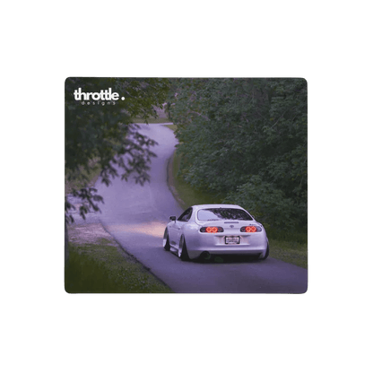 Large extended mouse pad featuring a white Toyota Supra Mk4 driving on a winding tree-lined road at dusk with throttle logo.