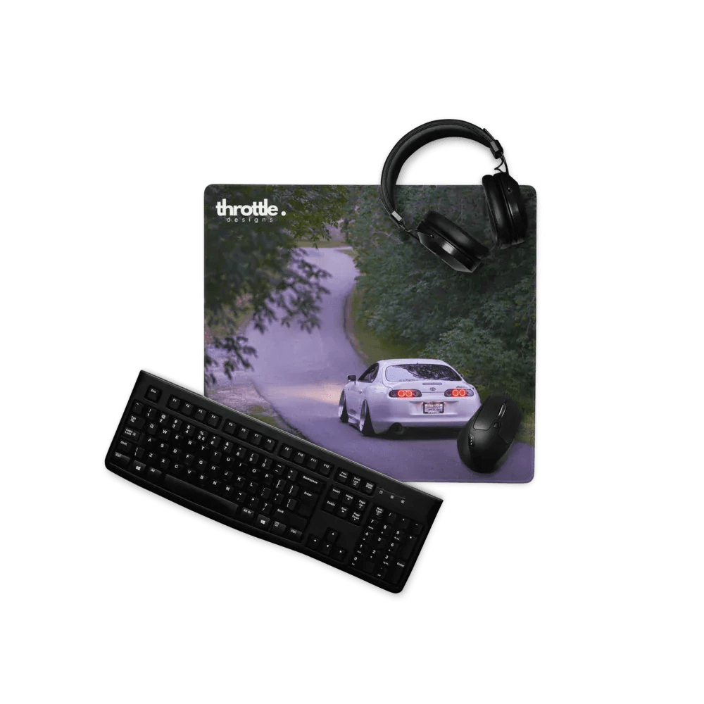 Extended gaming mouse pad featuring a white Toyota Supra Mk4 on a winding forest road, with smooth fabric surface and.